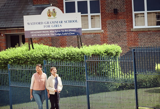 Two women walking outside Watford Grammar School