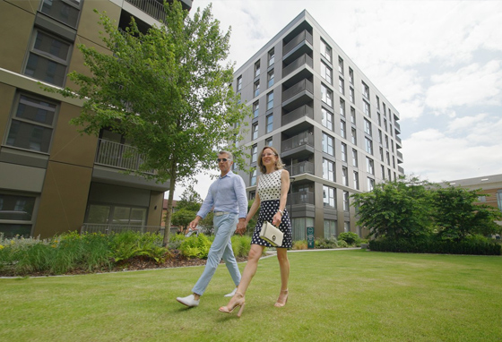 A couple walking across the grass outside Eden Grove in Staines, Surrey