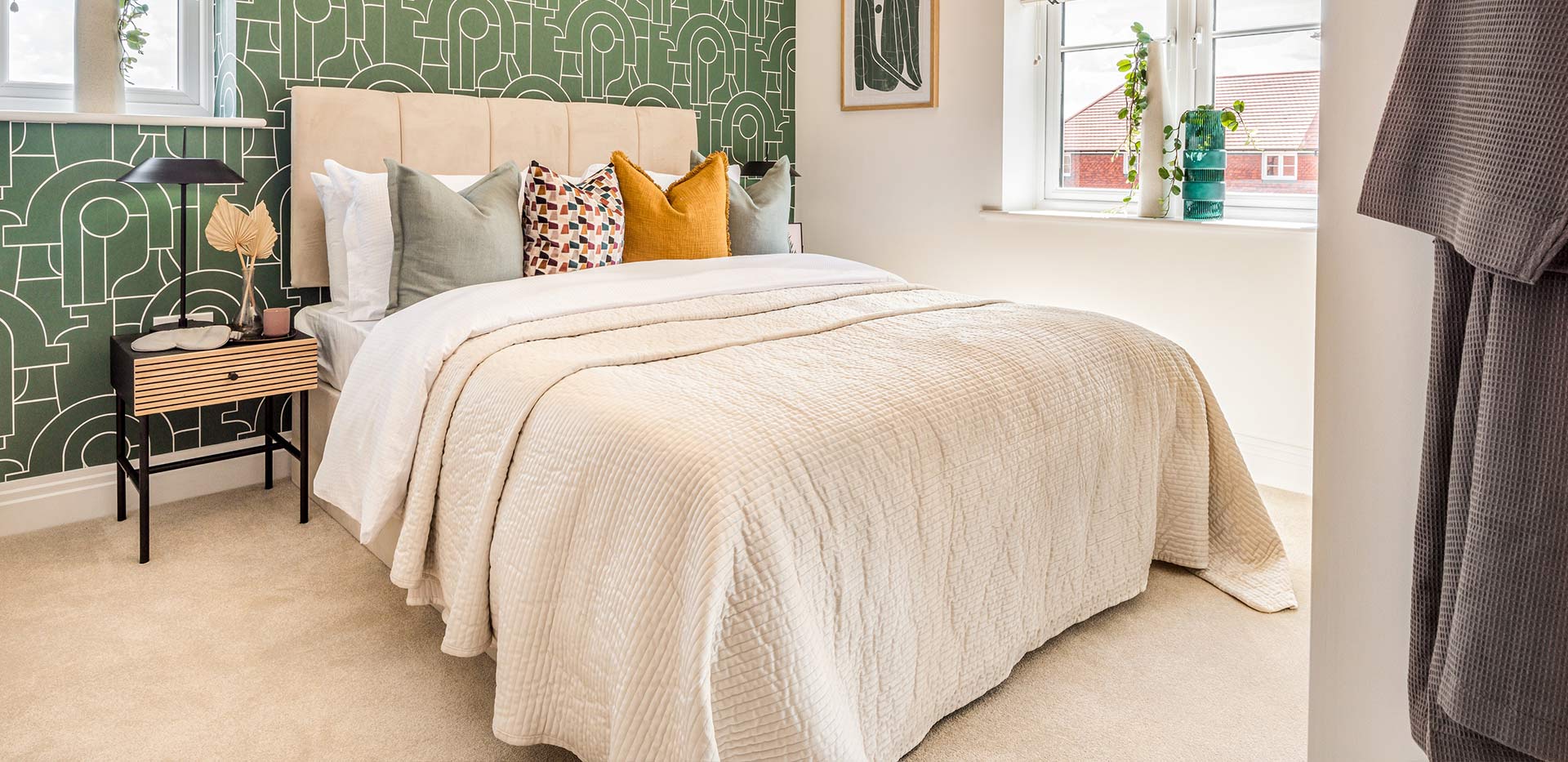 An interior Bedroom with a green feature wall image of Apartment 188 at Dorsett House at Abbey Barn Park