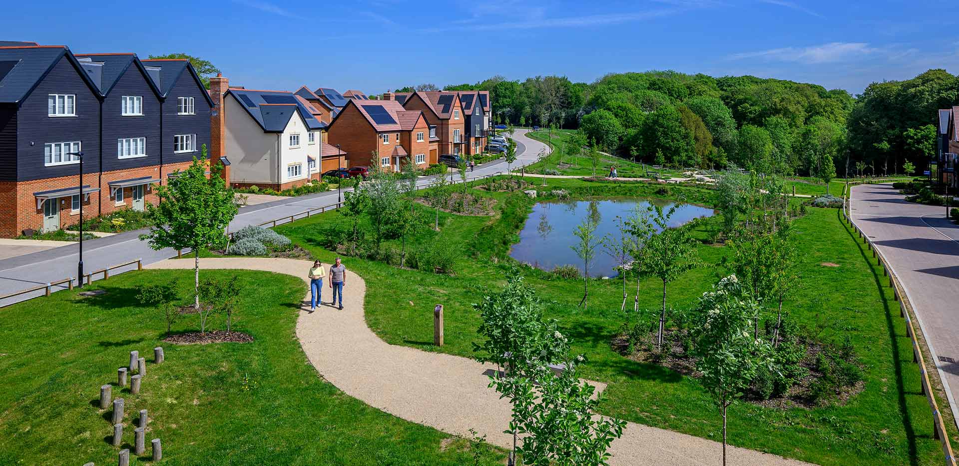 An exterior street scene of Abbey Barn Park showing green space and ponds
