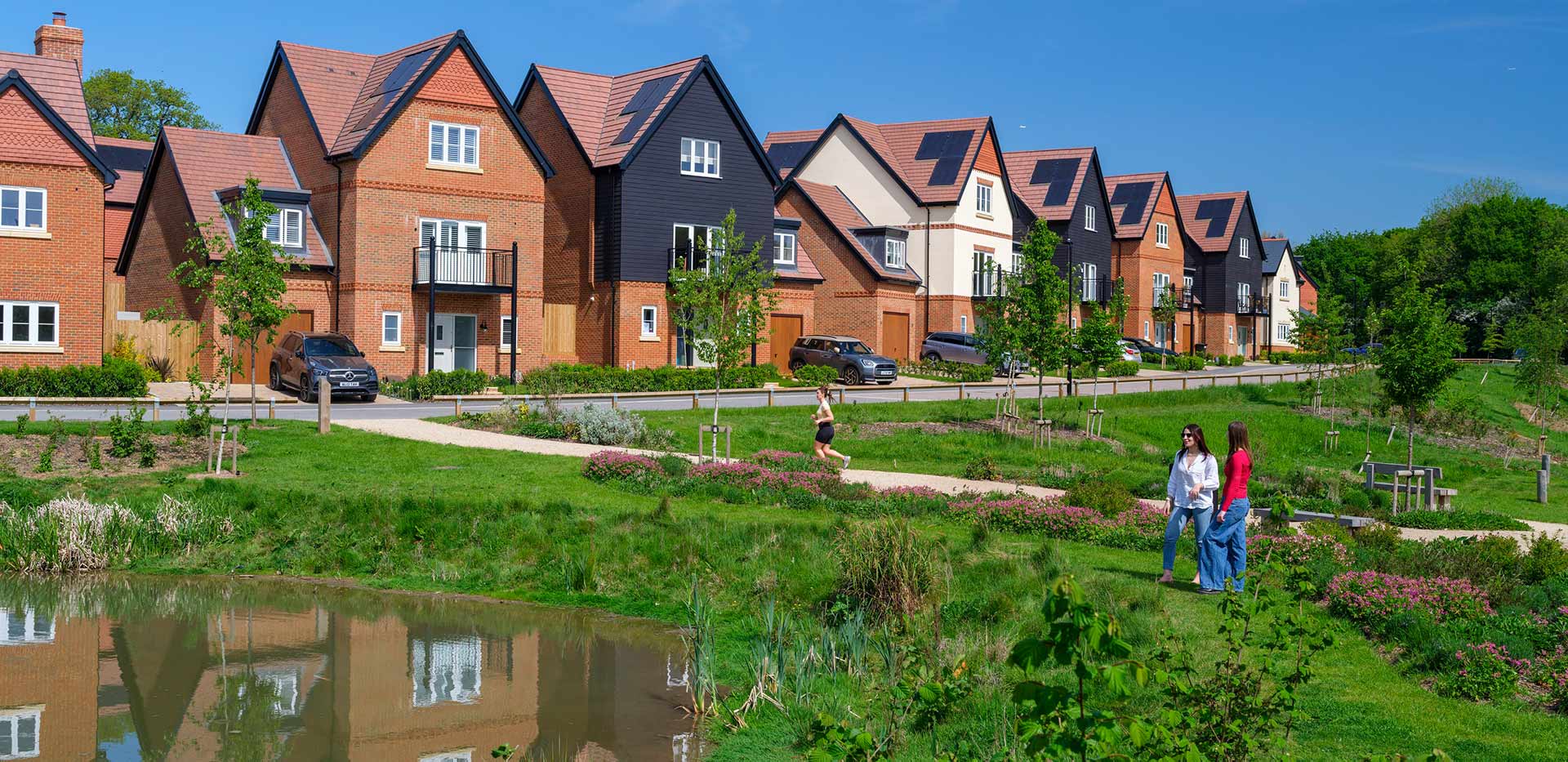 An exterior view from the green space and pond walkway to the Street of Houses at Abbey Barn Park