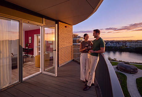 An image of a couple standing on their balcony at Bankside Gardens