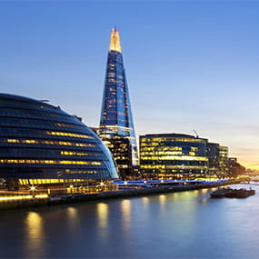 Evening scene of the Thames with modern buildings along the riverbank