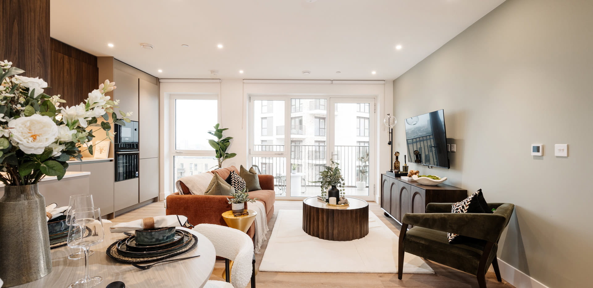 Dining area in foreground, modern designed and decorated living space in background.