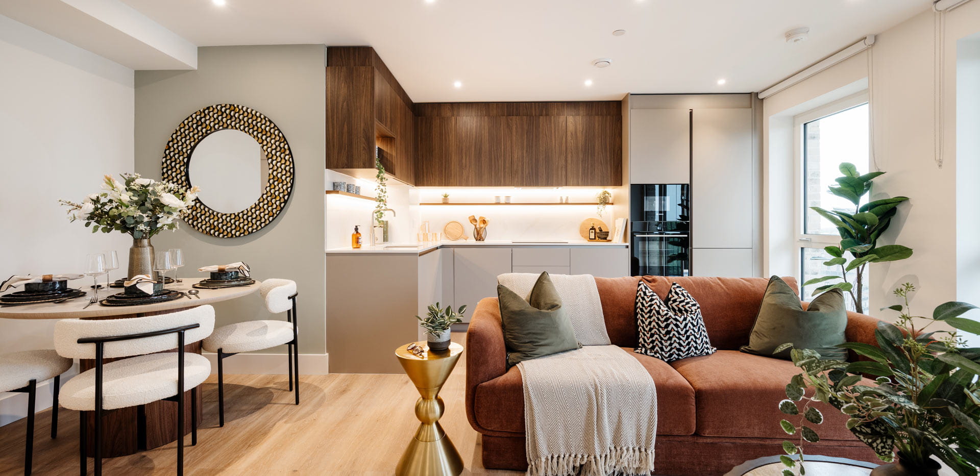 Living space in foreground, kitchen with dining table in background.