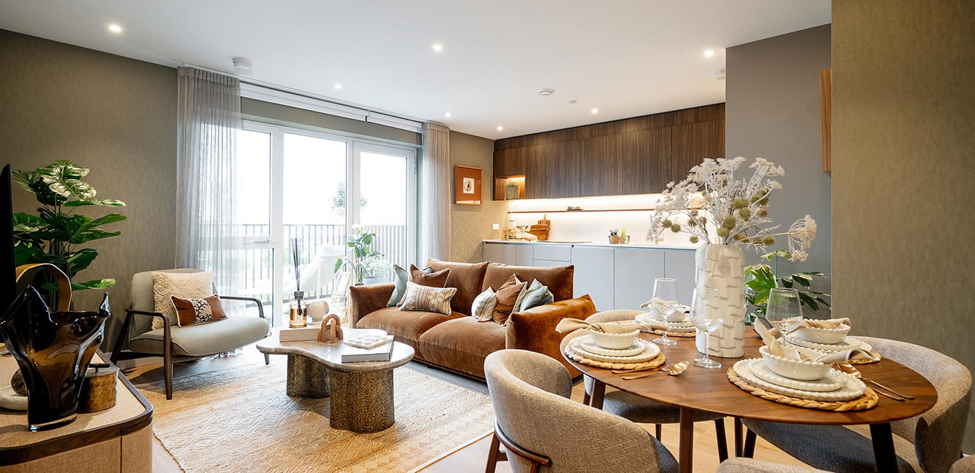 Decorated circular dining table in foreground, modern designed living space in background.