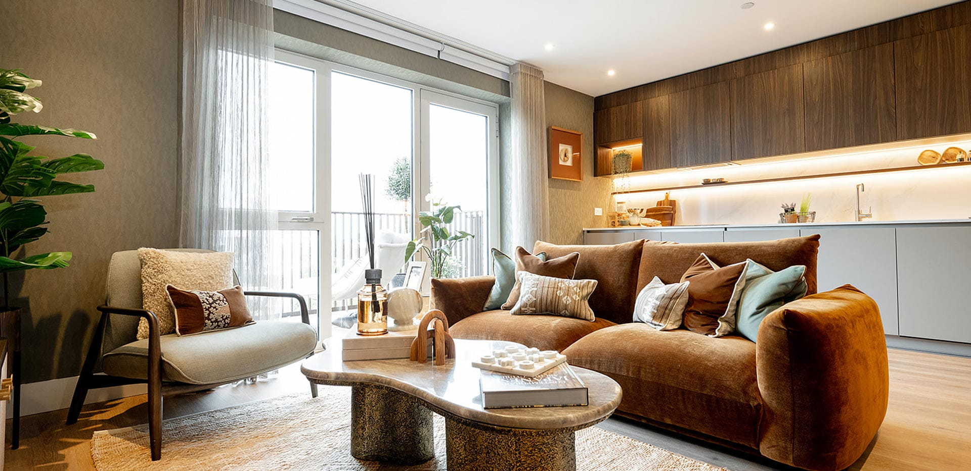 Modern designed living space with fabric sofa, wooden coffee table, armchair and indoor plants.
