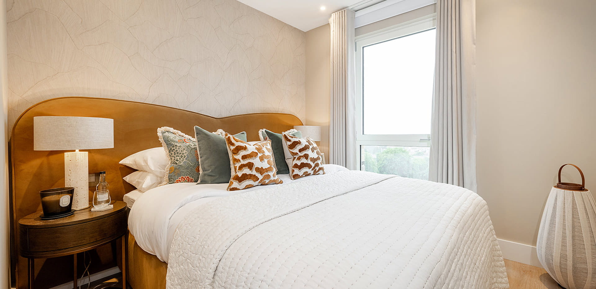 Double bed, orange headboard and bedside tables.