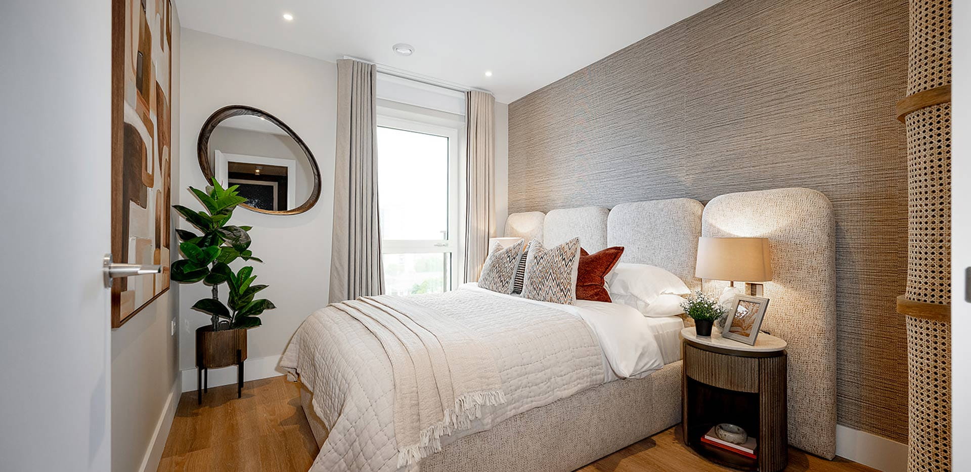 Double bed with contemporary design, bedside tables and wall hanging.