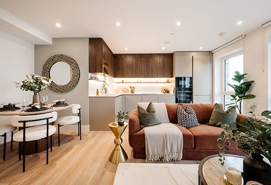 Modern designed and decorated living dining space with kitchen in background.