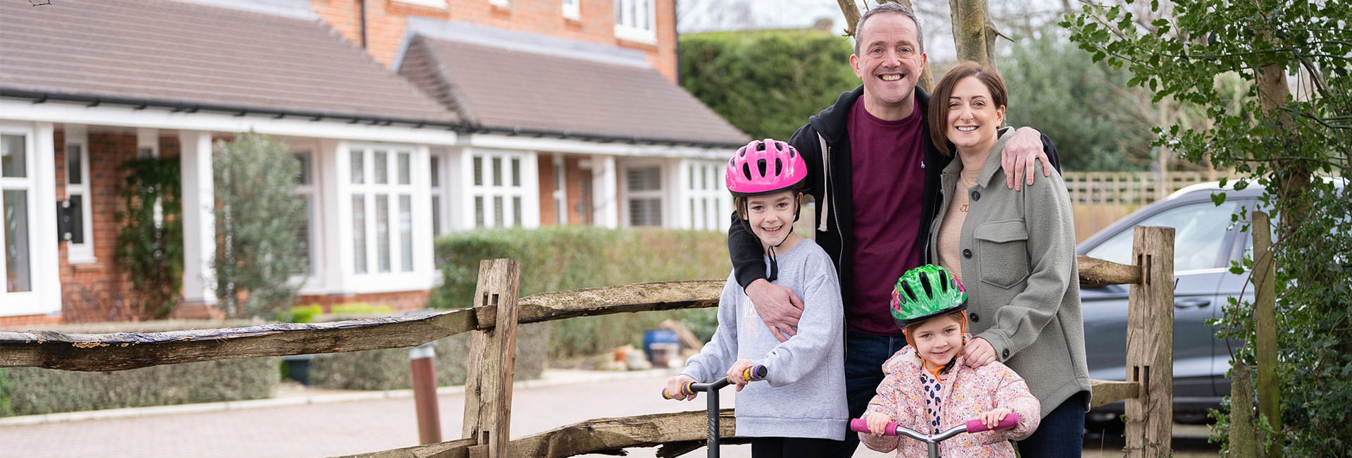 The Trewin family smiling for a photo in front of their new home in Sussex.
