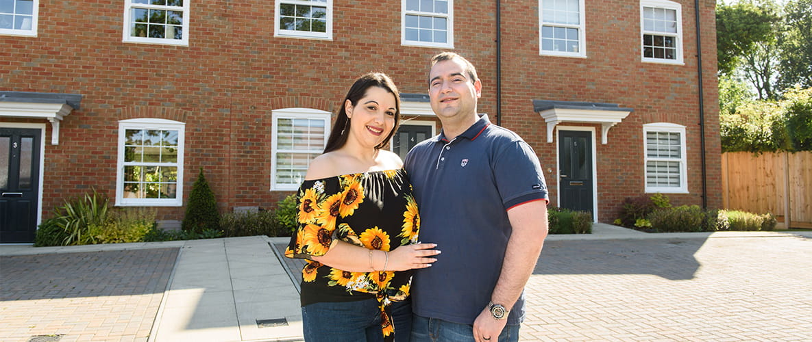 An image of the newly married couple outside their new home
