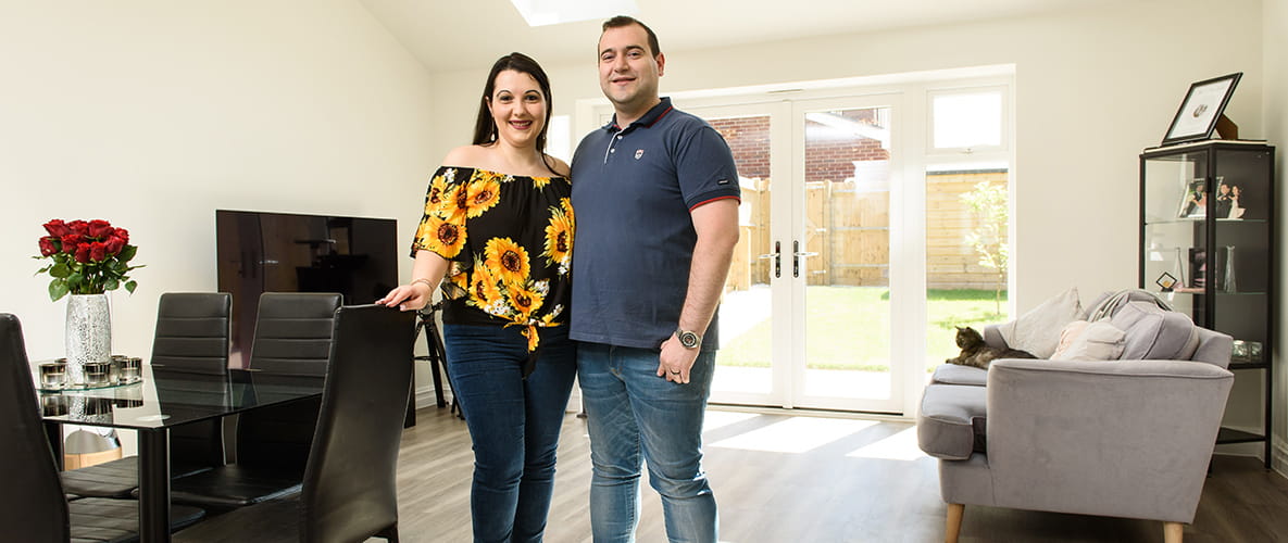 An image of the newly married couple standing in their family / dining area