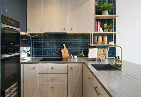 Kitchenette with breakfast island wraparound counters, splashwalls decorated in dark blue green tiles