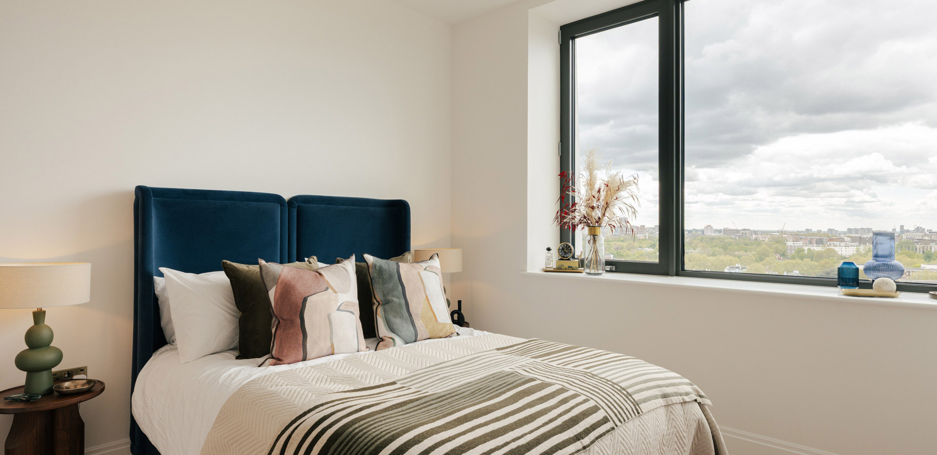 Double bed with contemporary design, bedside tables and wide window for ample natural lighting.