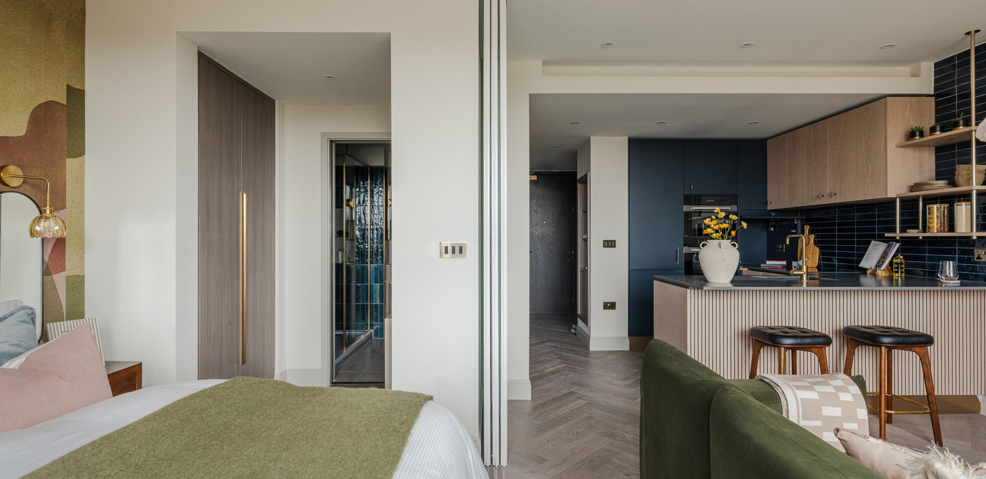 View of bedside, sofa and hallway in background.