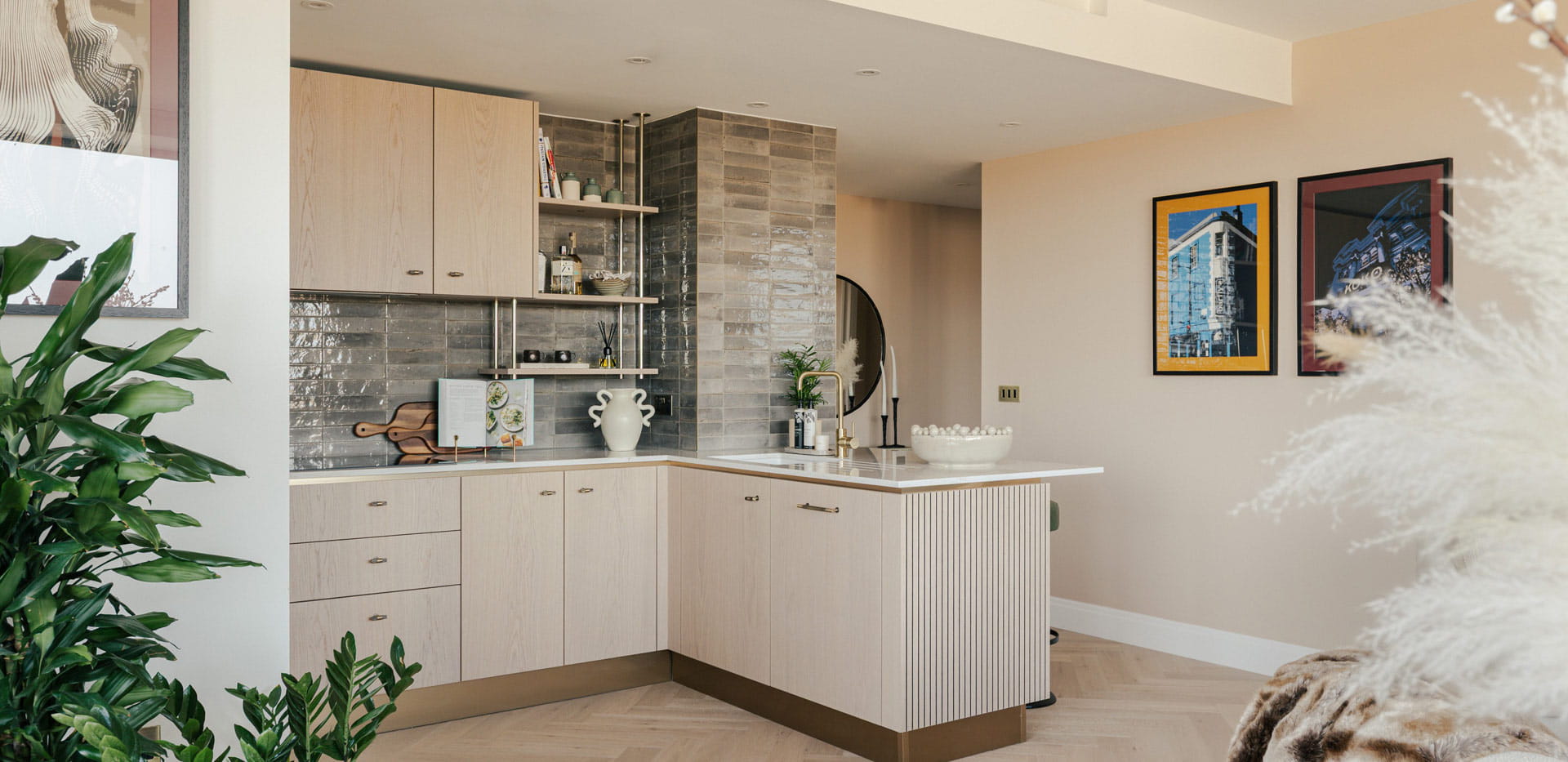 Kitchenette with breakfast island, beige cupboard panels and white countertops.