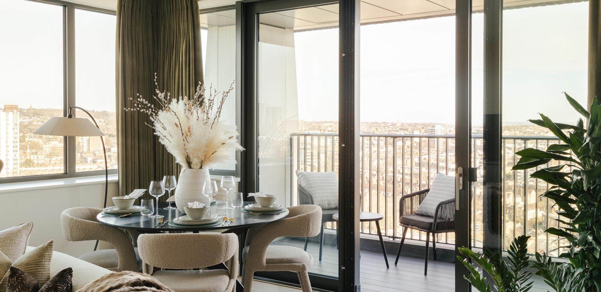 Dining table in corner with wrap around windows and balcony doors.