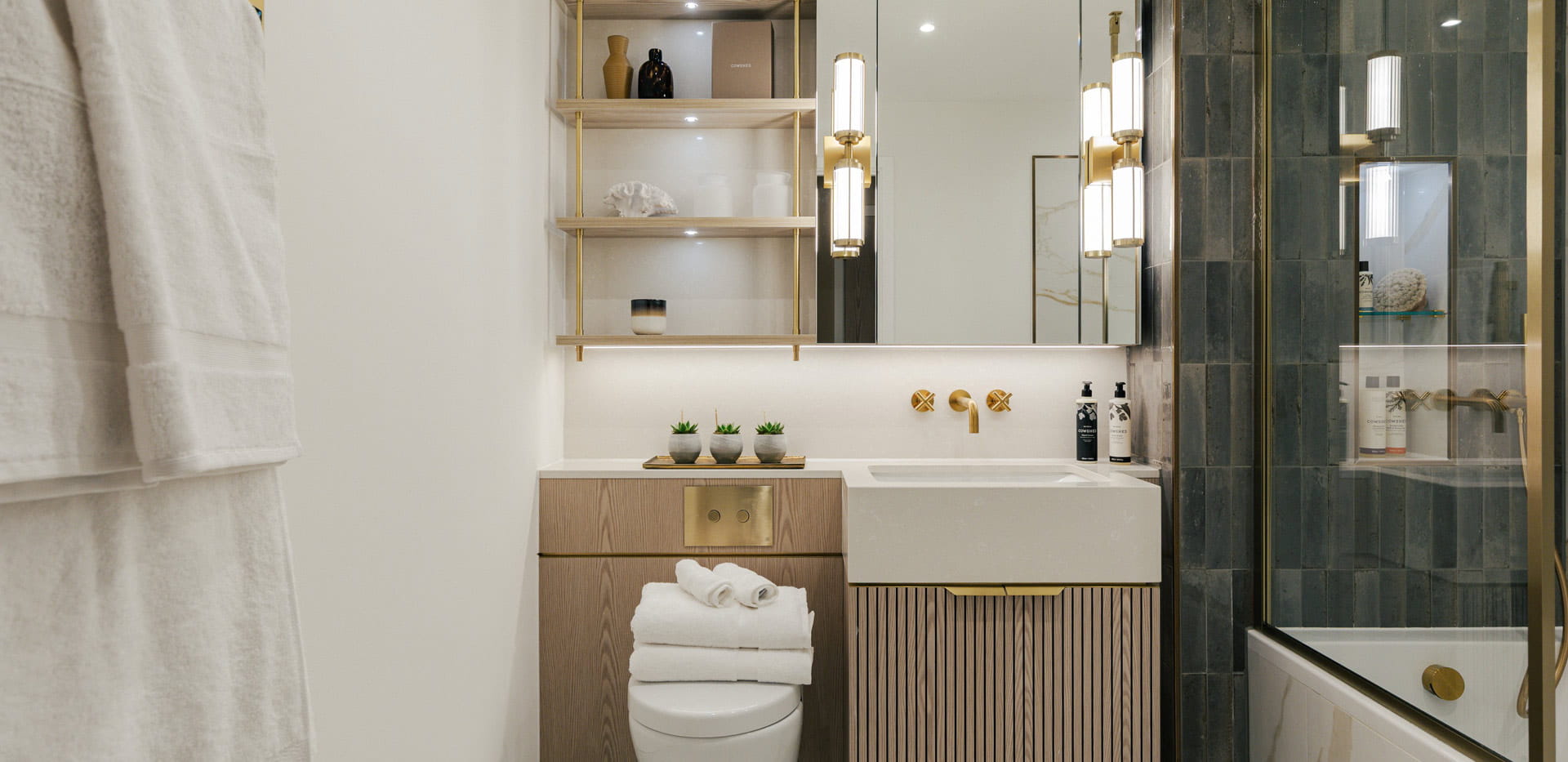 bathroom with shower over bath, wash basin with cabinet mirror and shelving.