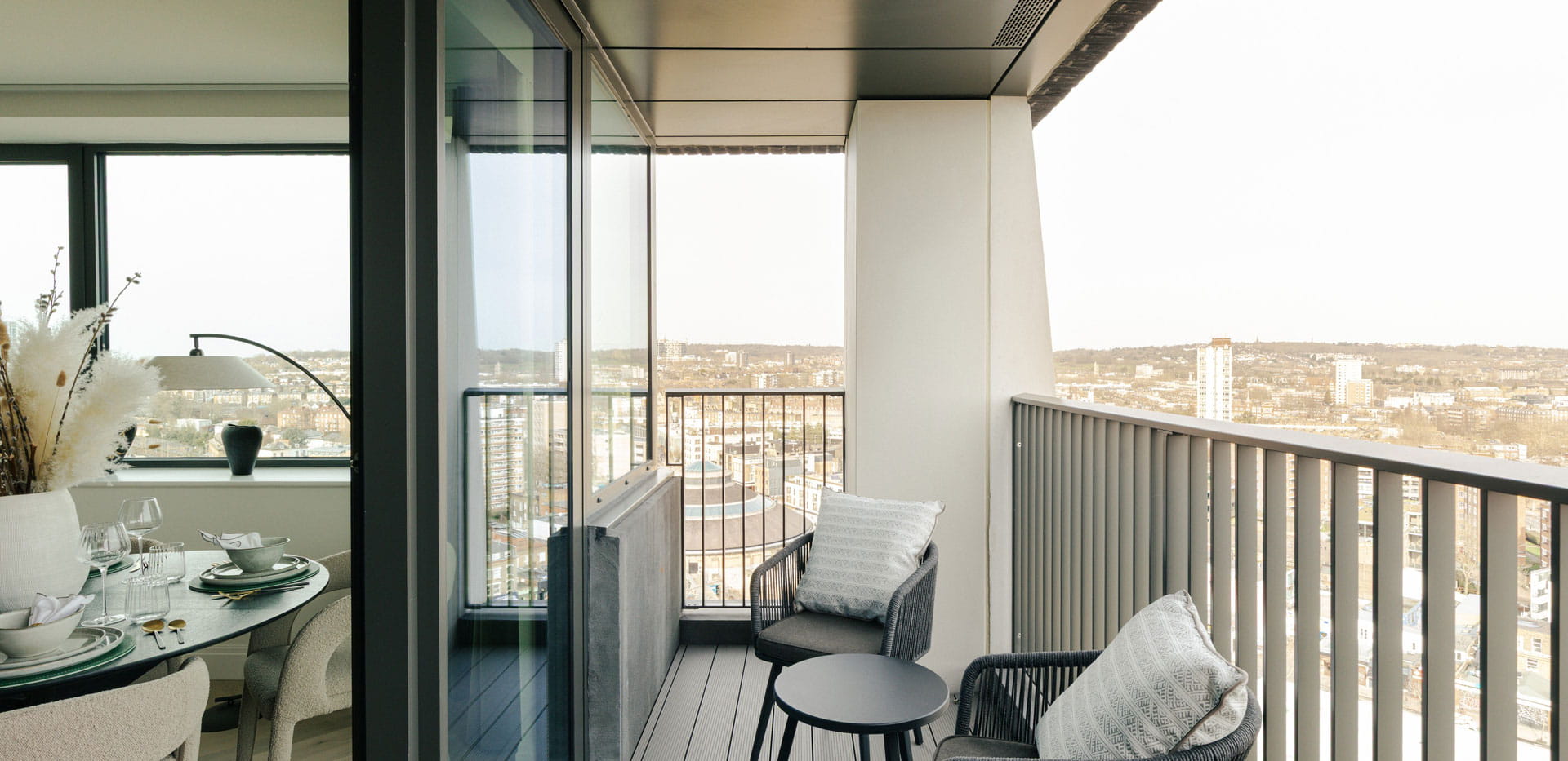 Balcony with outdoor furniture overlooking city view.