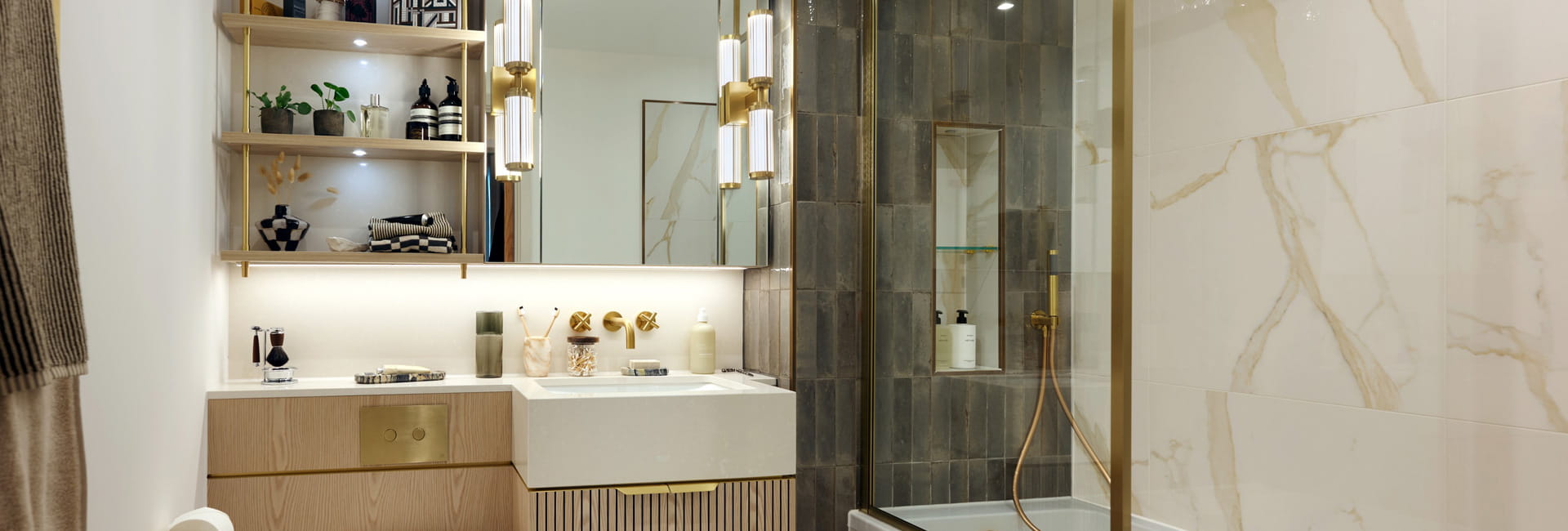 Modern designed bathroom with shower over bath, wash basin with wall mirror, toilet and cabinet space