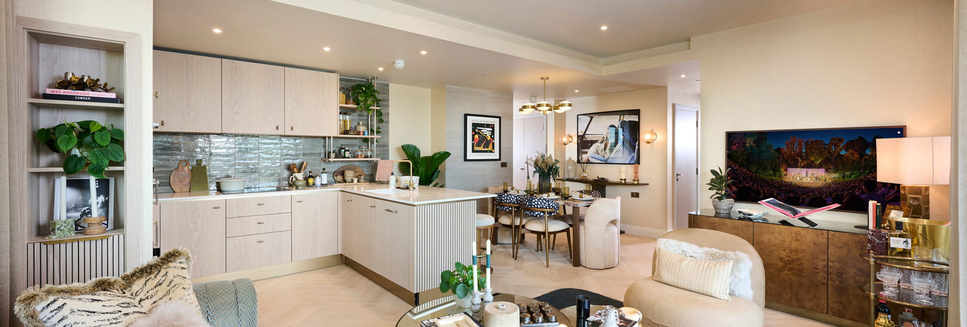 Living space in foreground, kitchen with attached kitchen island, dining table in background