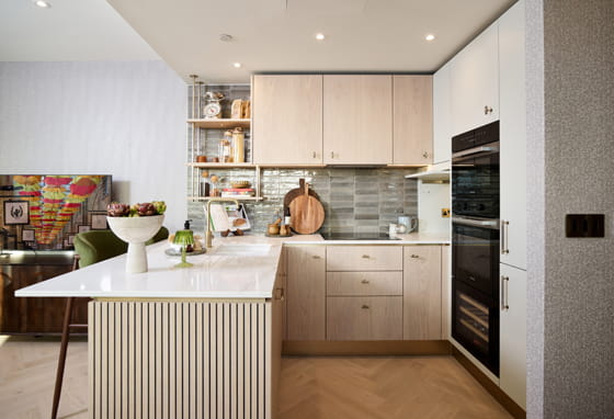 Kitchenette with breakfast island with white countertops, cream cabinets and drawers