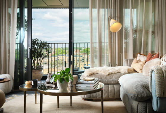 Living space with large balcony glass sliding doors, chaise lounge and round coffee table