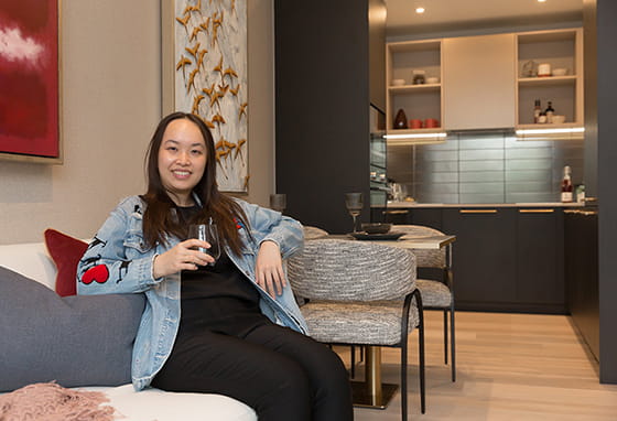 An image of Aurora in the living area with the dining / kitchen in the background