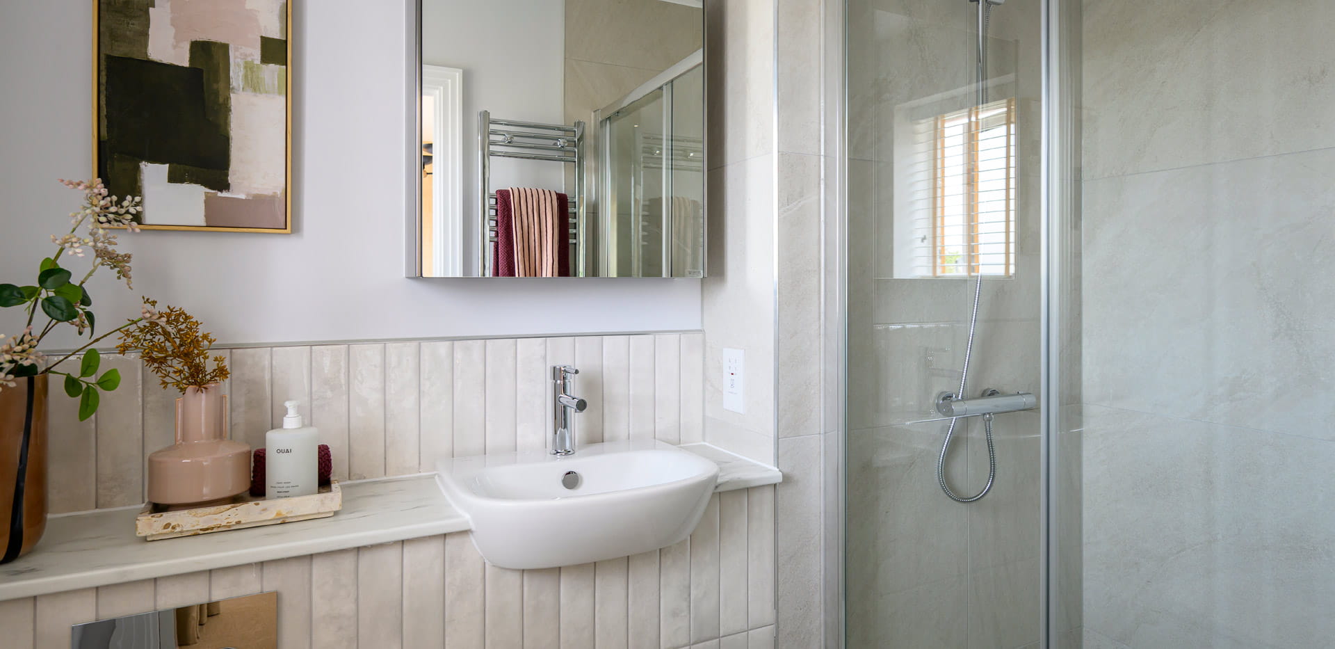 Modern designed bathroom with shower unit, wash basin with wall mirror.