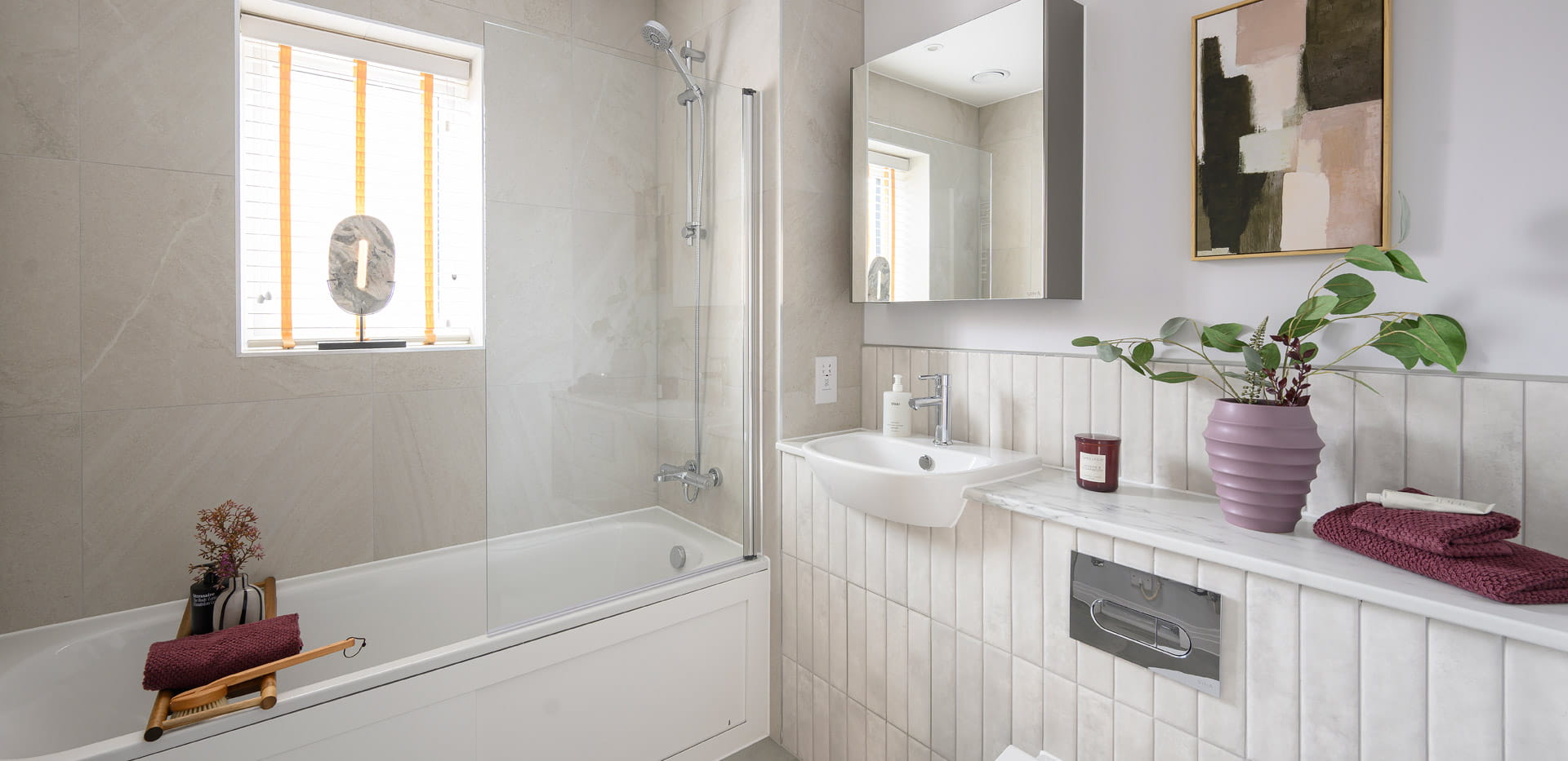Modern designed bathroom with shower over bath , wash basin with wall mirror, shelf space.