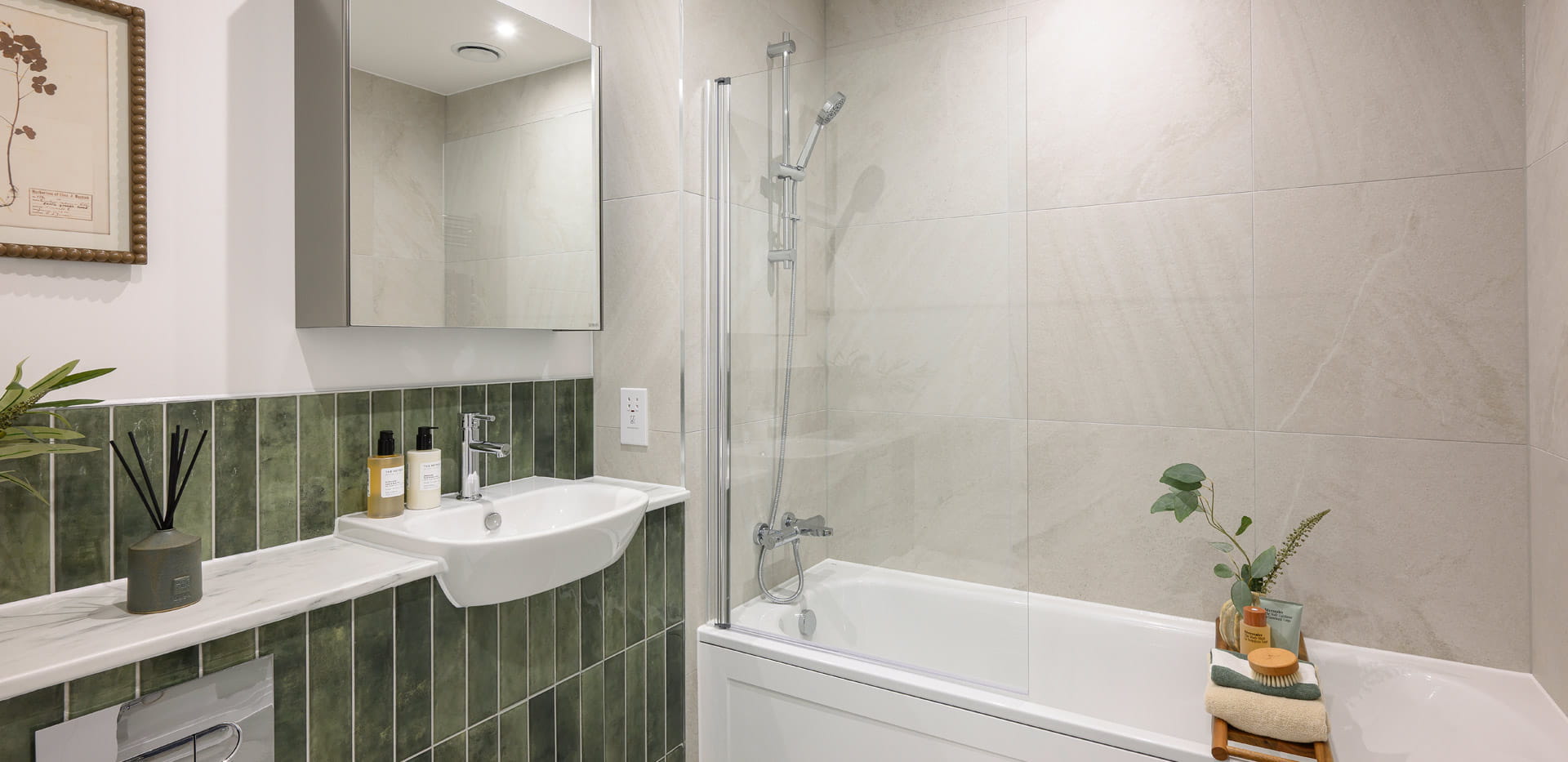 Modern designed bathroom with shower over bath, wash basin with wall mirror, shelf space.