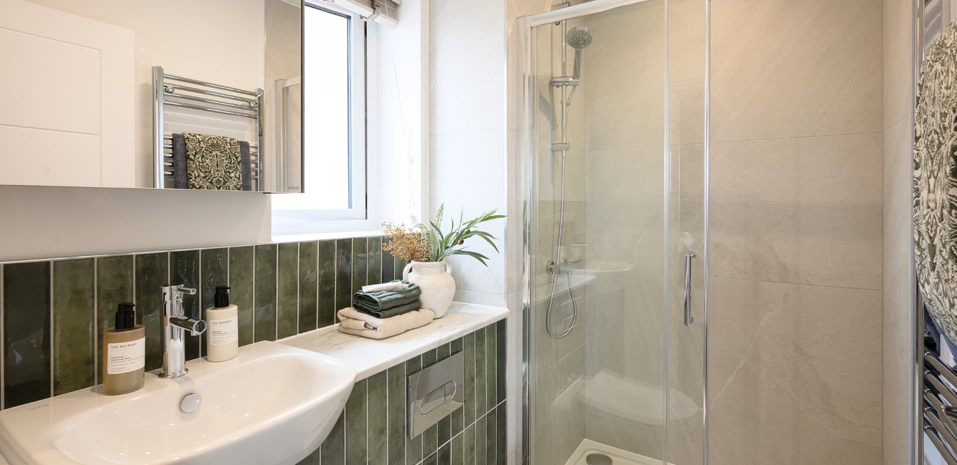 Modern designed bathroom with shower unit, wash basin with wall mirror, shelf space.