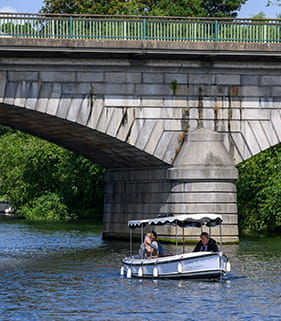 A boat sailing under a bridge