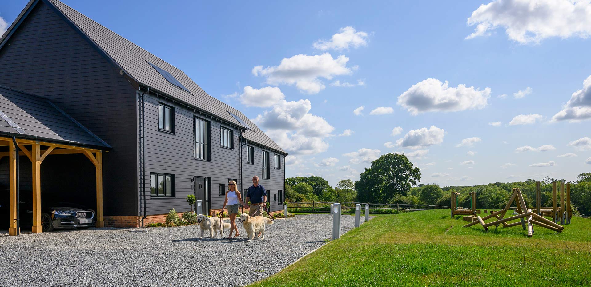 An exterior image of Farmstead residents walking their dogs around the beautiful open landscape that surrounds the development