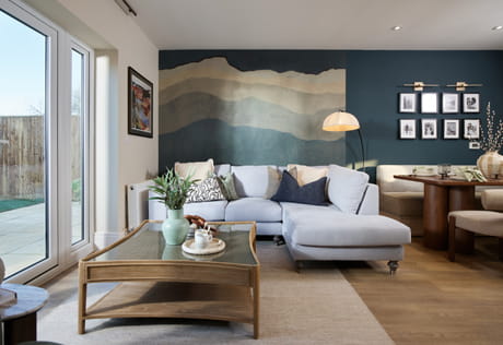 Living space with sofa and coffee table, patio doors and dining area adjacent