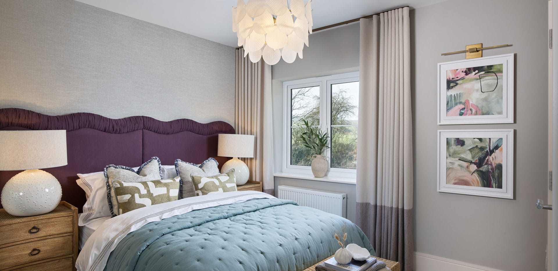 Double bed with purple headboard and light grey walls