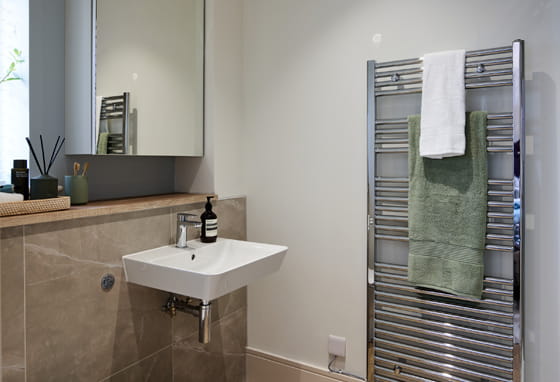 Close-up photo of towel rack, wash basin and mirror in a Foal Hurst Green home