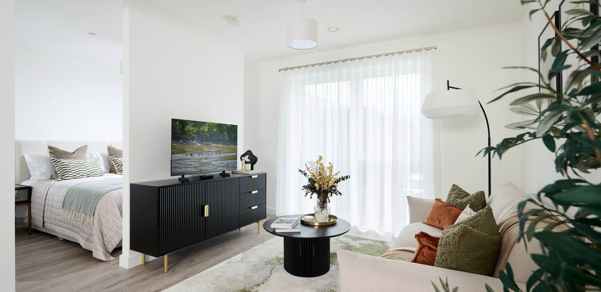 Modern designed and decorated living area with bedroom behind wall.