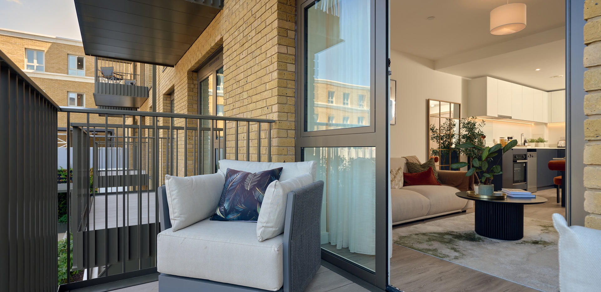 Closeup of balcony and outdoor furniture, interior is living space.
