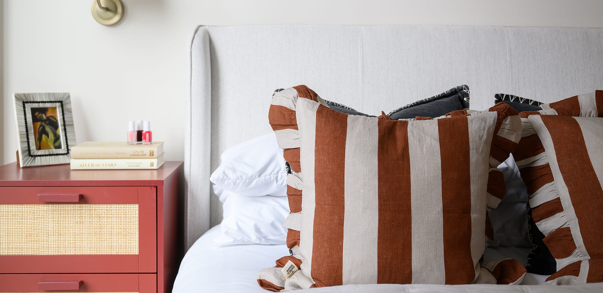 Close up image of a bedroom with stripy cushions
