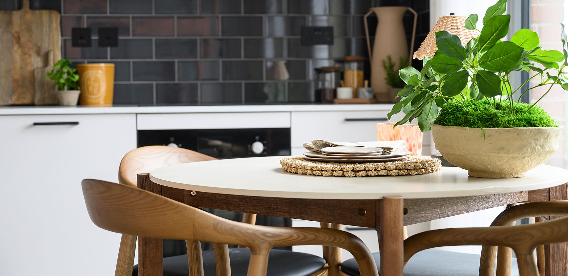 An image of the dining area with the kitchen in the background