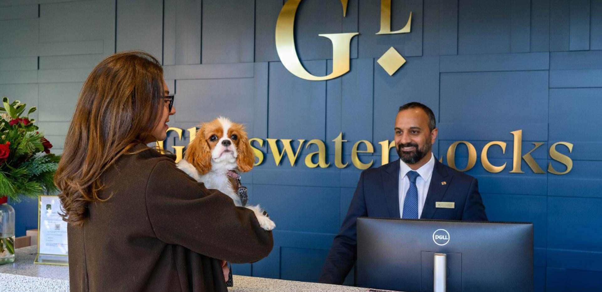 Glasswater Locks resident's facilities showing concierge desk, representative addressing a "customer" holding a puppy