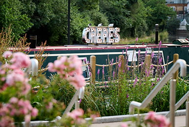 A canal boat with a sign above that reads 'Crepes'.