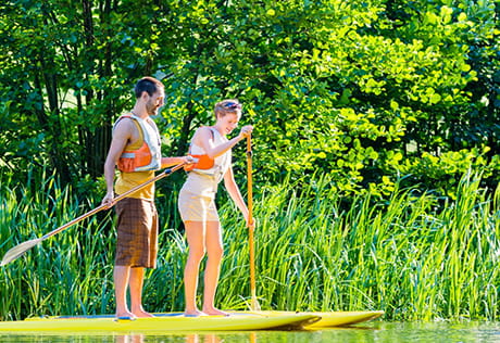 An image of a couple paddle boarding