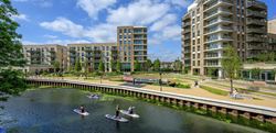Residents paddle boarding on the water outside the Grand Union development