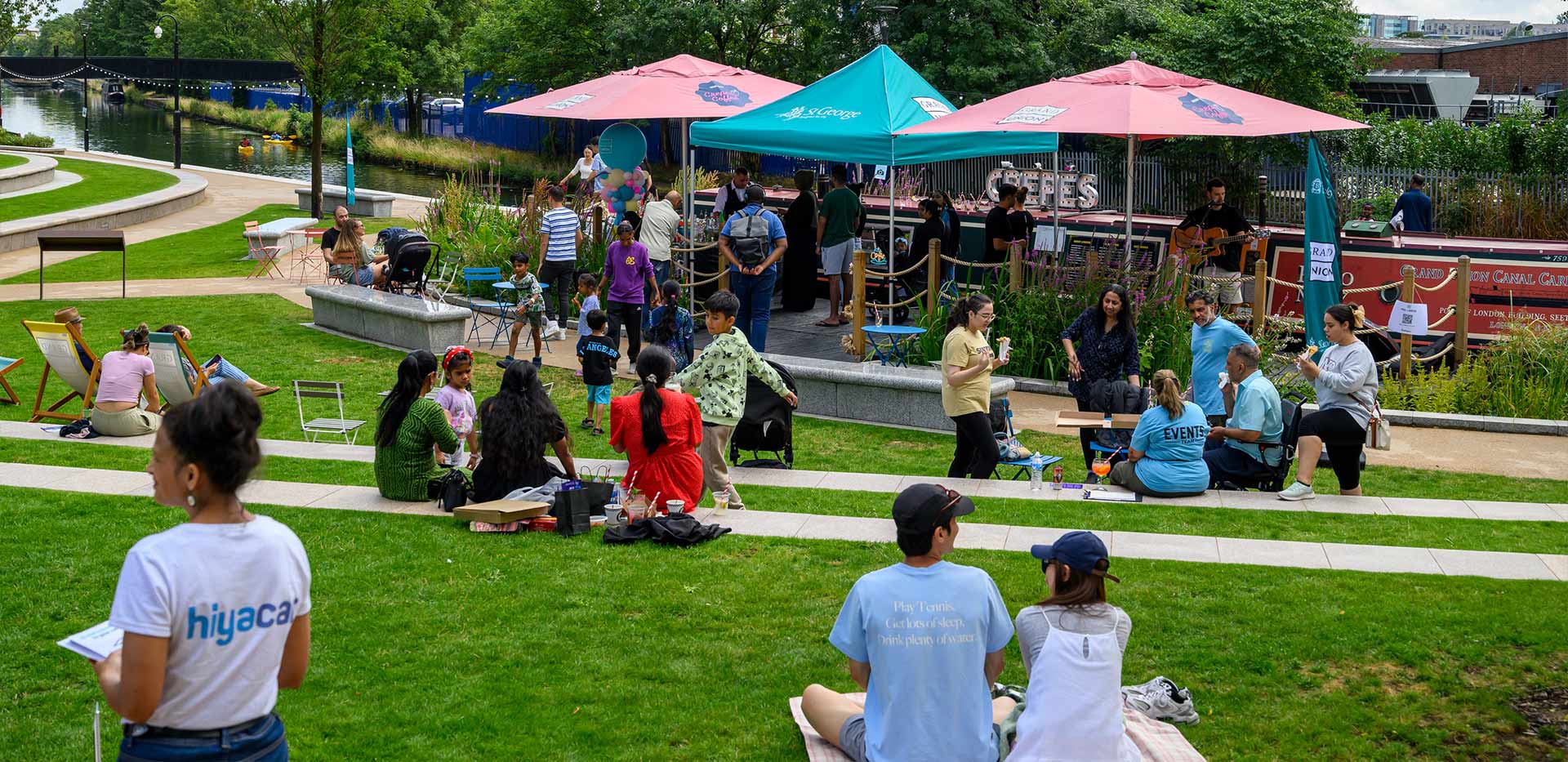 An image of people sat on the grass around the Pavlo Boat