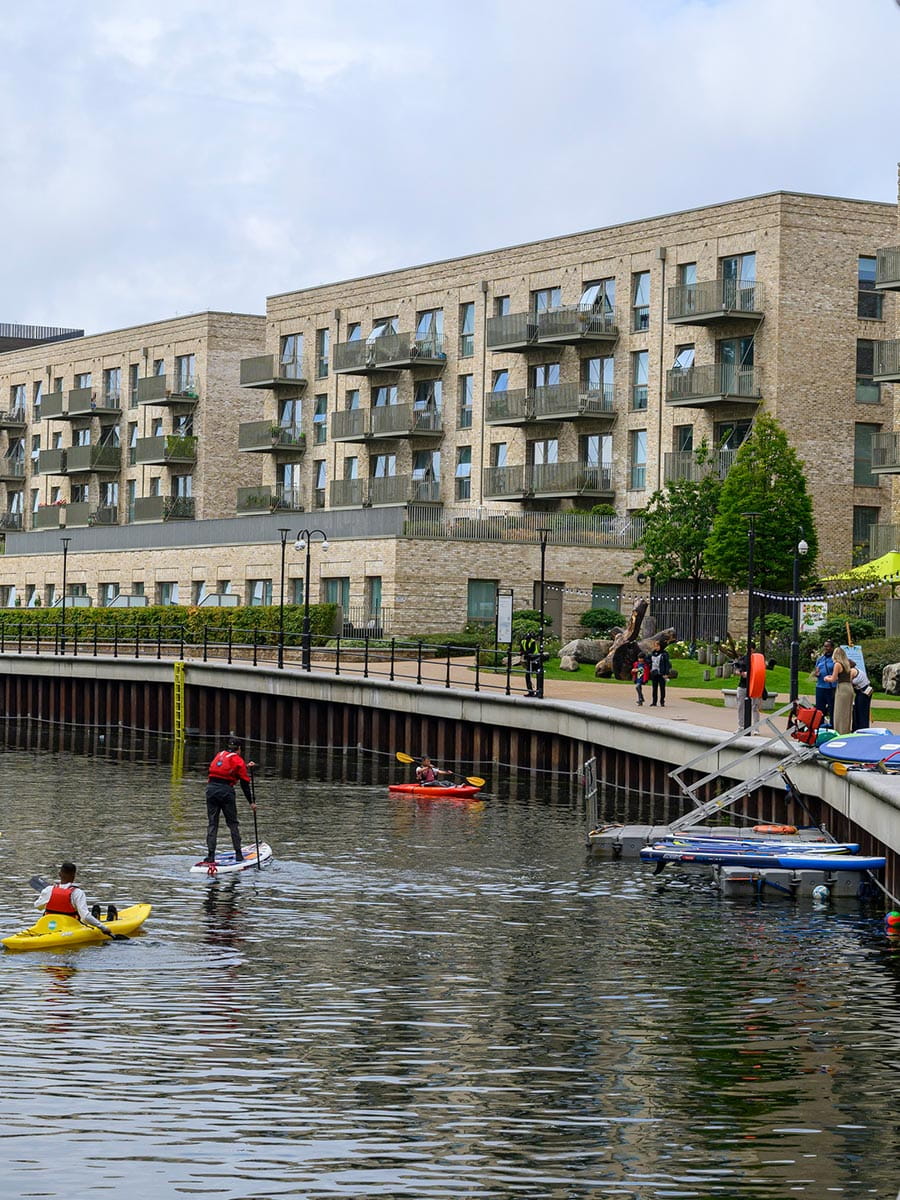 An image of people paddle boarding and kayaking on the canal at Grand Union