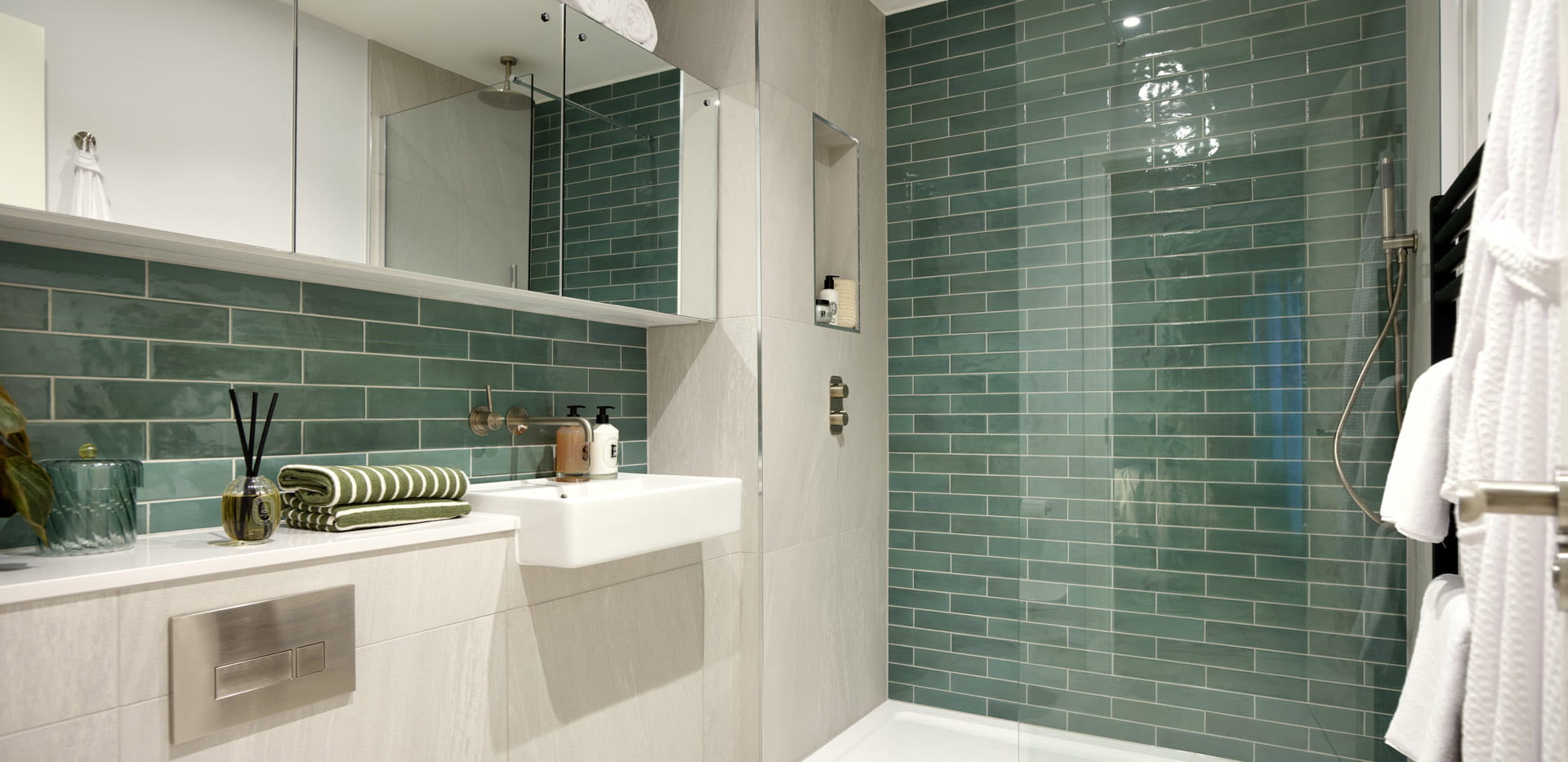 Modern designed bathroom with shower unit, wash basin with cabinet mirror, toilet and cabinet space