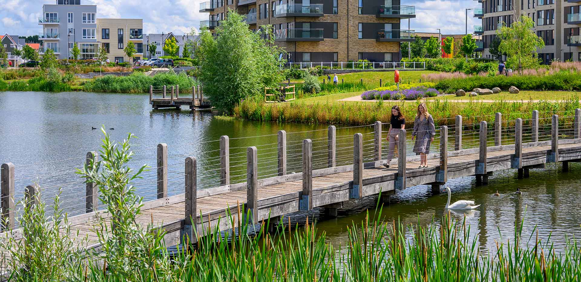 Green Park Village lake with two women walking along the bridge